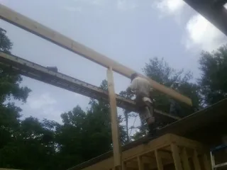 Carpenter setting a ridge beam over a new addition frame — Ice Dam Removal by Roofing Brothers in North Prairie