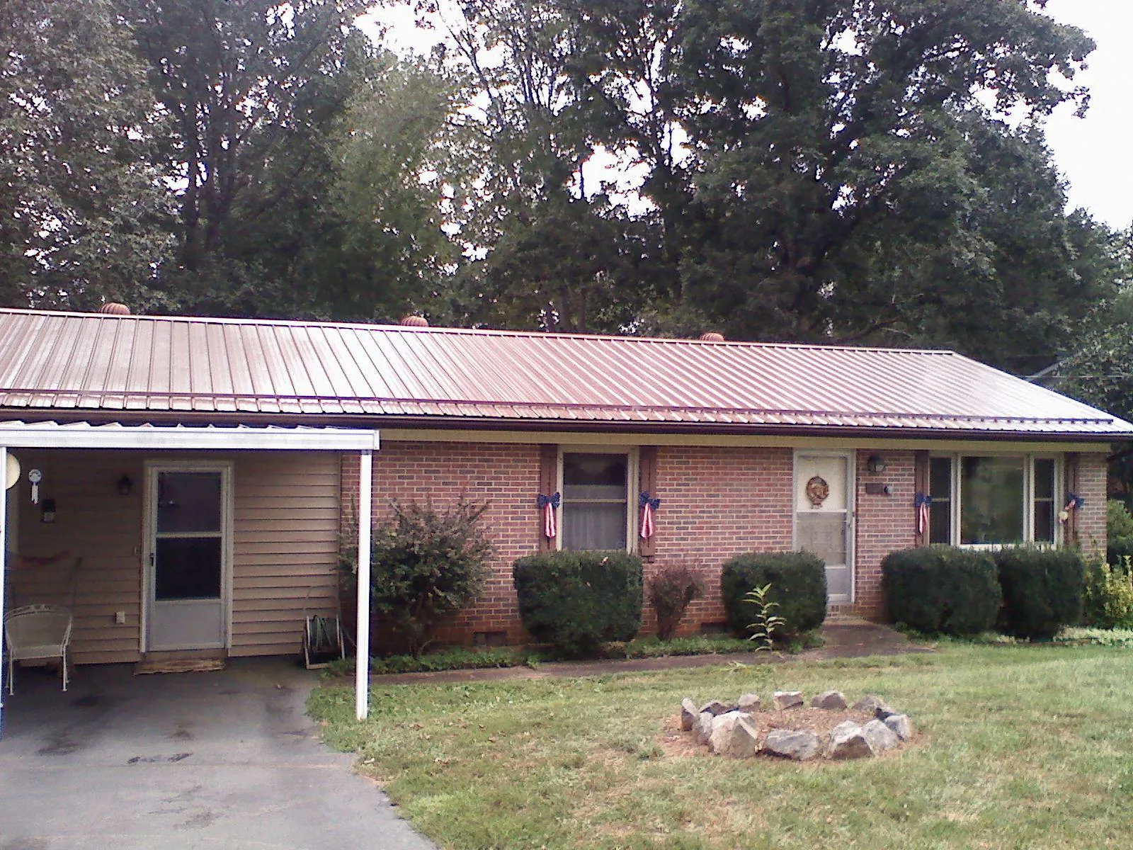 Bronze metal roof and carport on a brick ranch home — Roof Repair work by our crew in North Prairie
